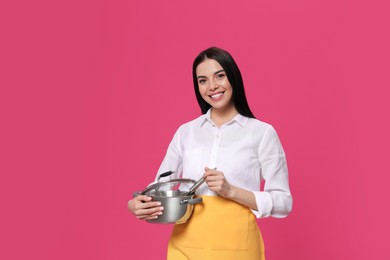 Photo of Young housewife with pan on pink background