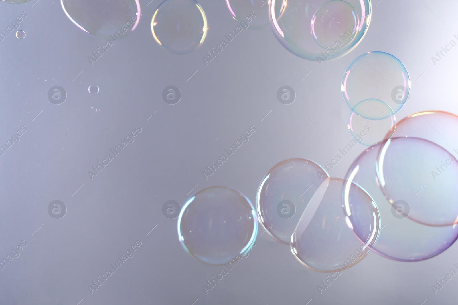 Photo of Beautiful transparent soap bubbles on gray background, space for text