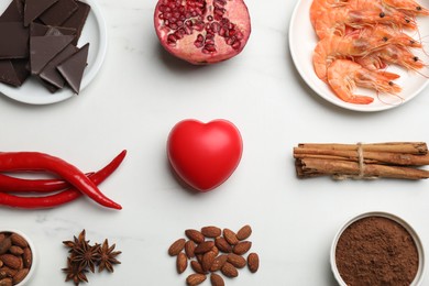 Photo of Natural aphrodisiac. Different products and heart model on white marble table, flat lay