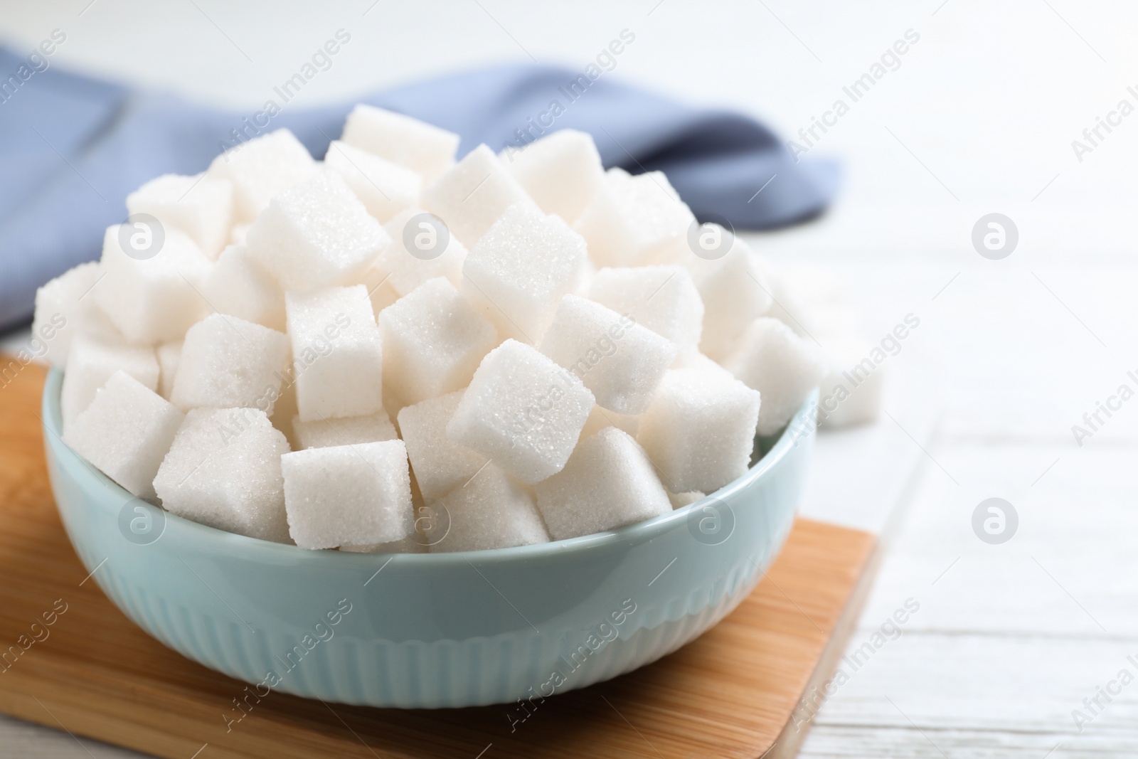 Photo of Refined sugar cubes on white wooden table