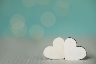 Decorative hearts on wooden table against blurred background, space for text. Valentine's Day