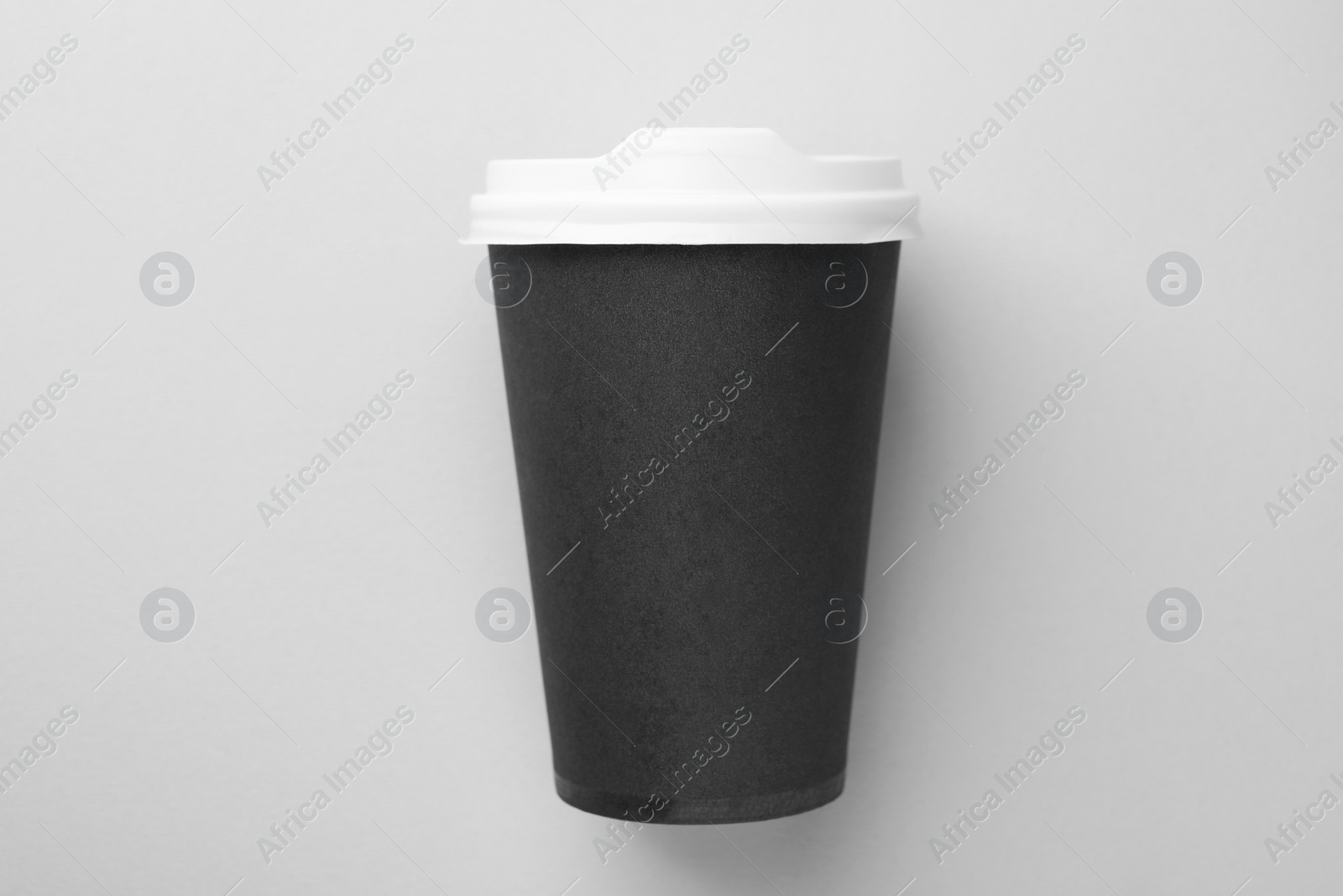 Photo of One paper cup on light grey background, top view. Coffee to go