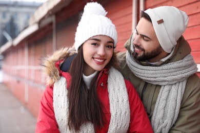 Photo of Happy young couple spending time together at winter fair. Christmas celebration