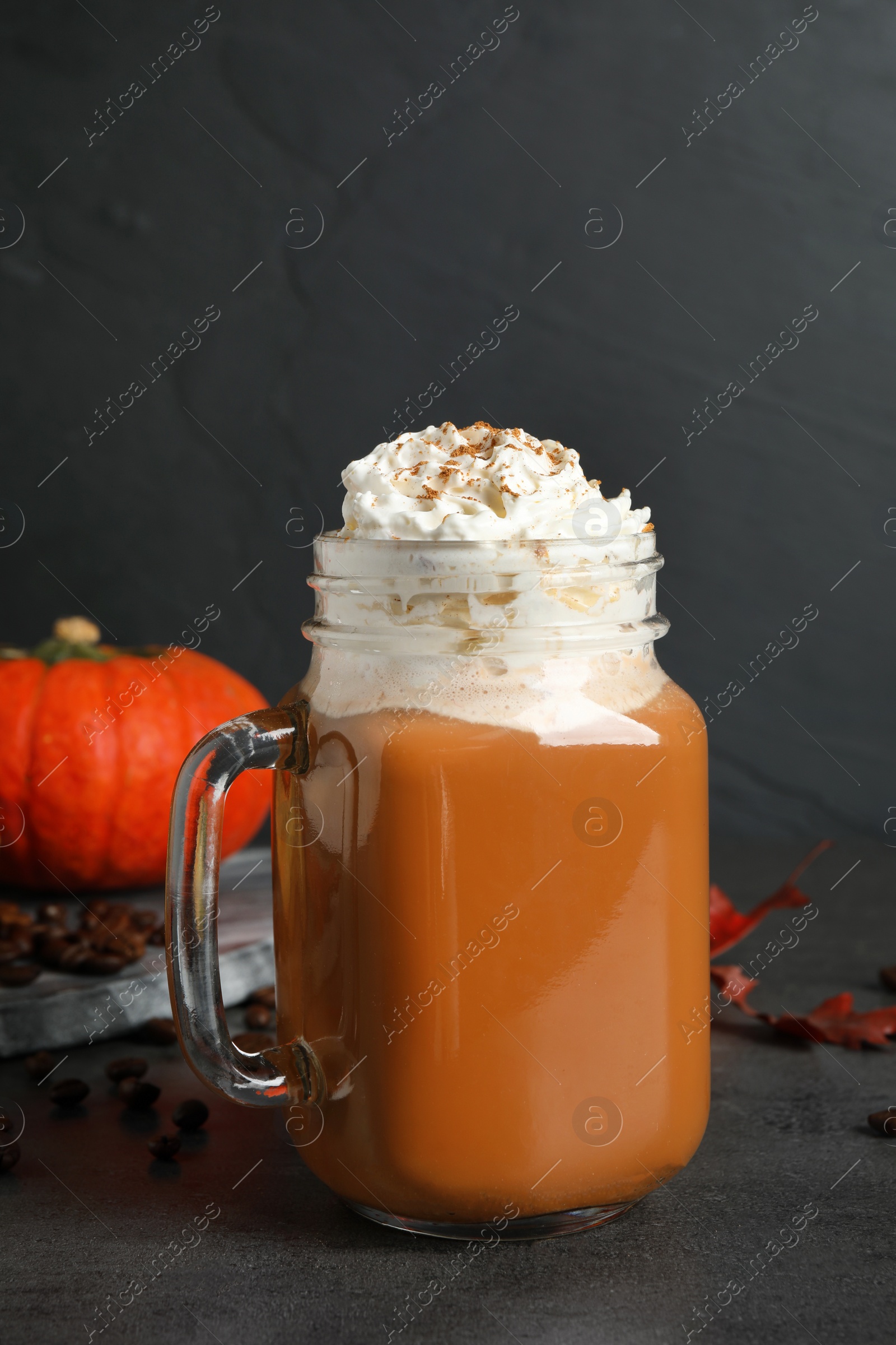 Photo of Mason jar with tasty pumpkin spice latte on grey table