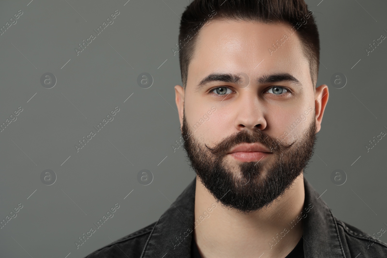 Photo of Portrait of young man with mustache on grey background. Space for text