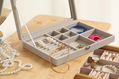 Jewelry boxes with many different accessories on wooden table, closeup