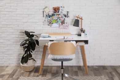 Stylish room interior with workplace and vision board