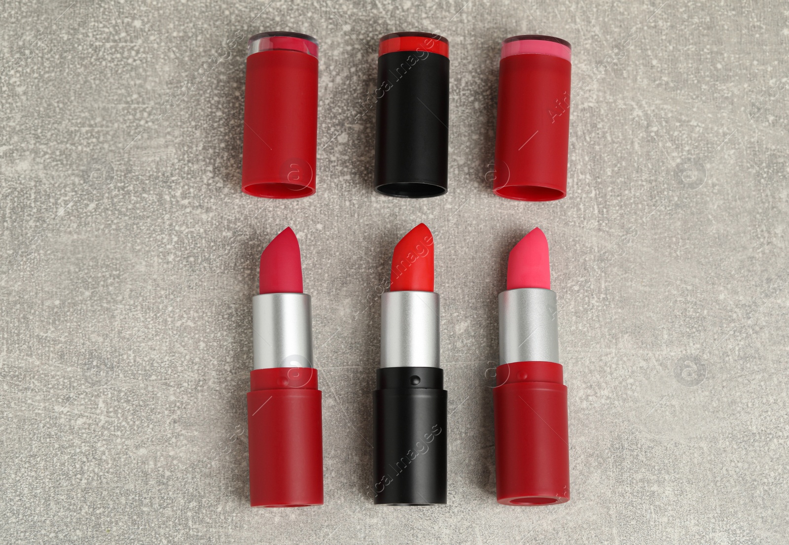 Photo of Different lipsticks on grey table, flat lay