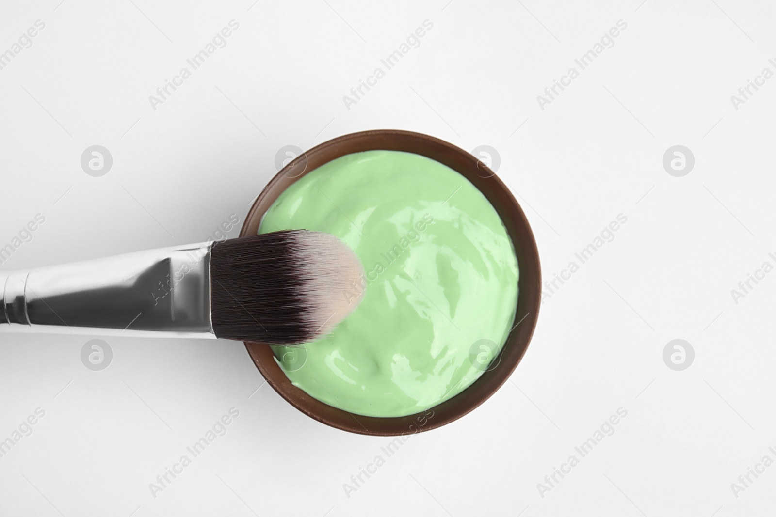 Photo of Professional face mask with brush on white background, top view