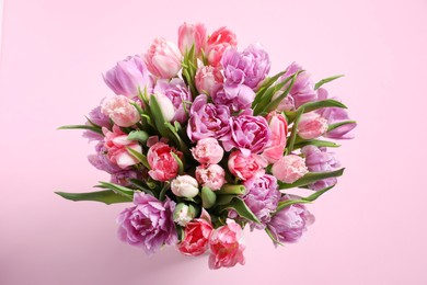 Beautiful bouquet of colorful tulip flowers on pink background, top view