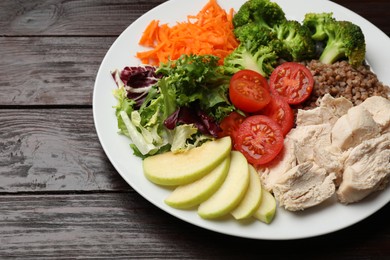 Photo of Balanced diet and healthy foods. Plate with different delicious products isolated on wooden table