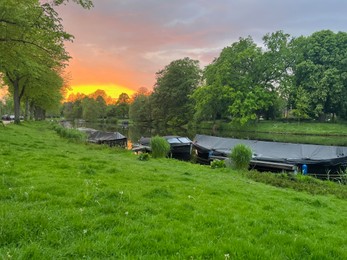 Photo of Scenic view of canal with moored boats at sunset