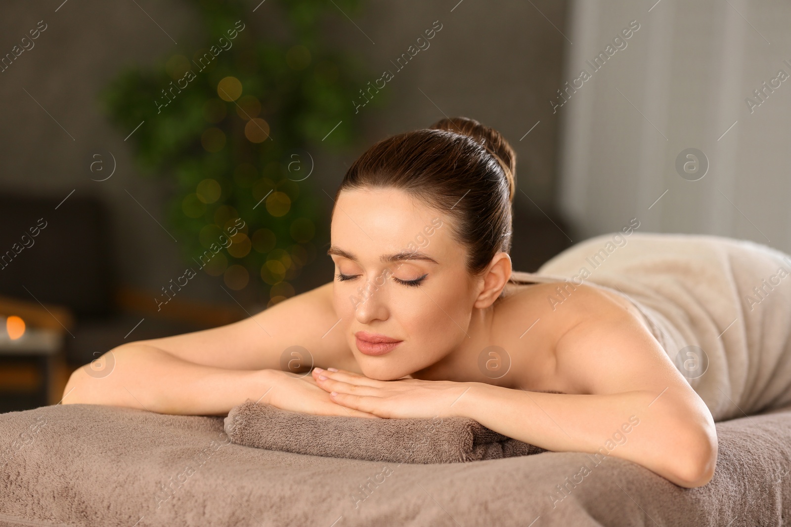 Photo of Beautiful young woman relaxing in spa salon