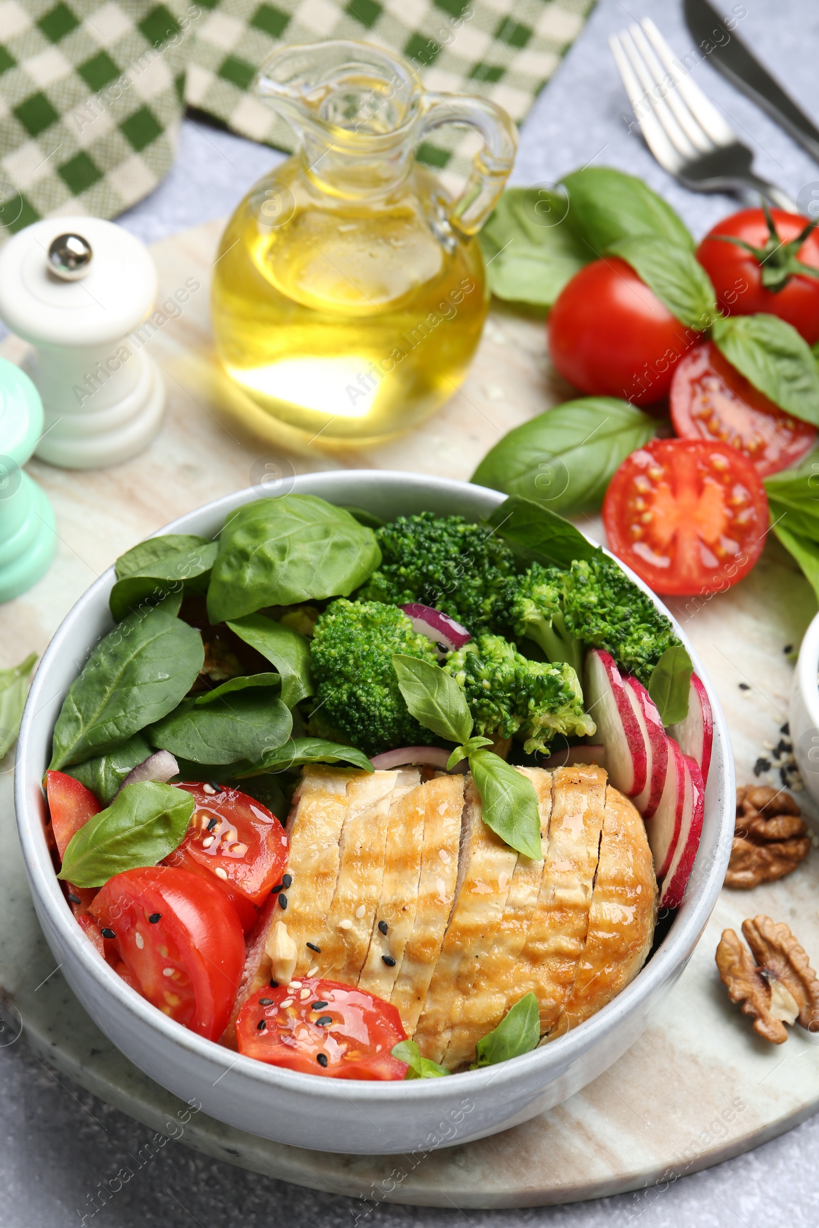 Photo of Healthy meal. Delicious chicken, vegetables and spinach served on light grey table