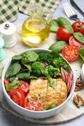 Healthy meal. Delicious chicken, vegetables and spinach served on light grey table