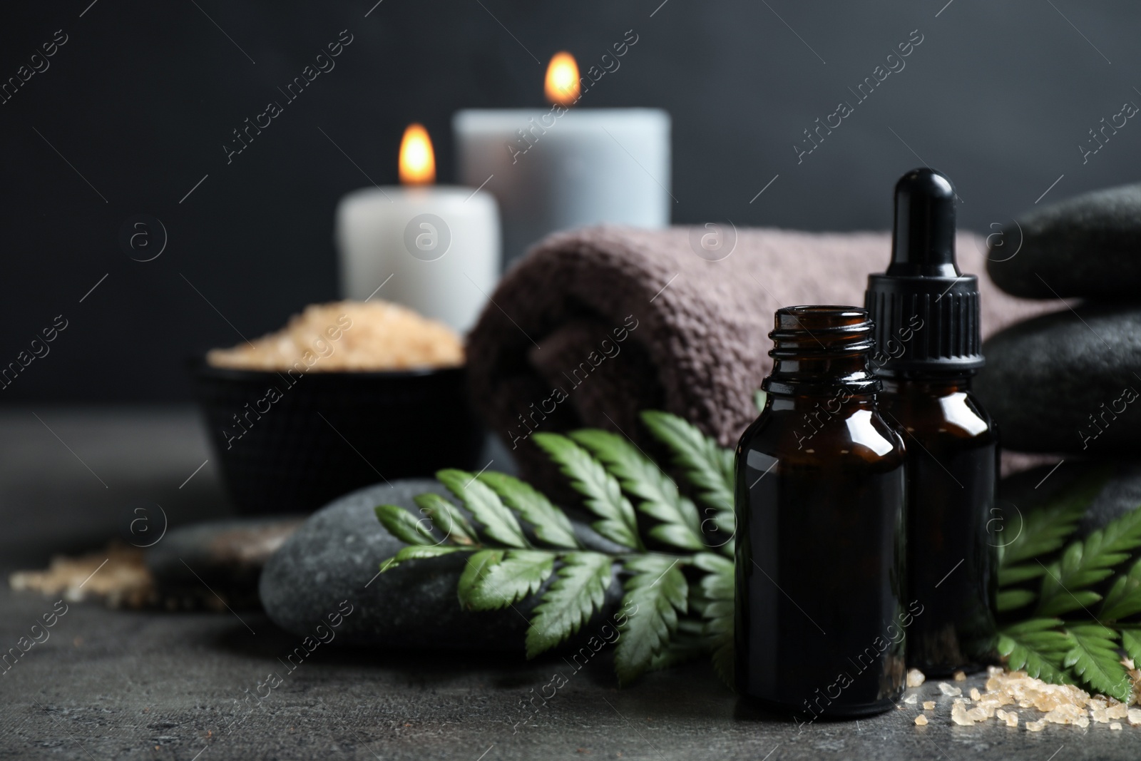 Photo of Spa composition with aroma oil on grey table, closeup. Space for text
