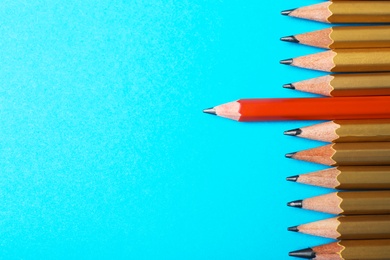 Photo of One different pencil standing out from others on color background, top view. Space for text