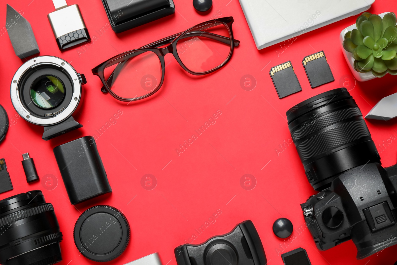 Photo of Flat lay composition with camera and video production equipment on red background. Space for text