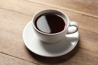 Photo of Cup of aromatic coffee on wooden table