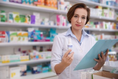 Photo of Professional pharmacist with clipboard and medicine in drugstore