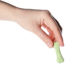 Woman holding bone shaped dog cookie on white background, closeup