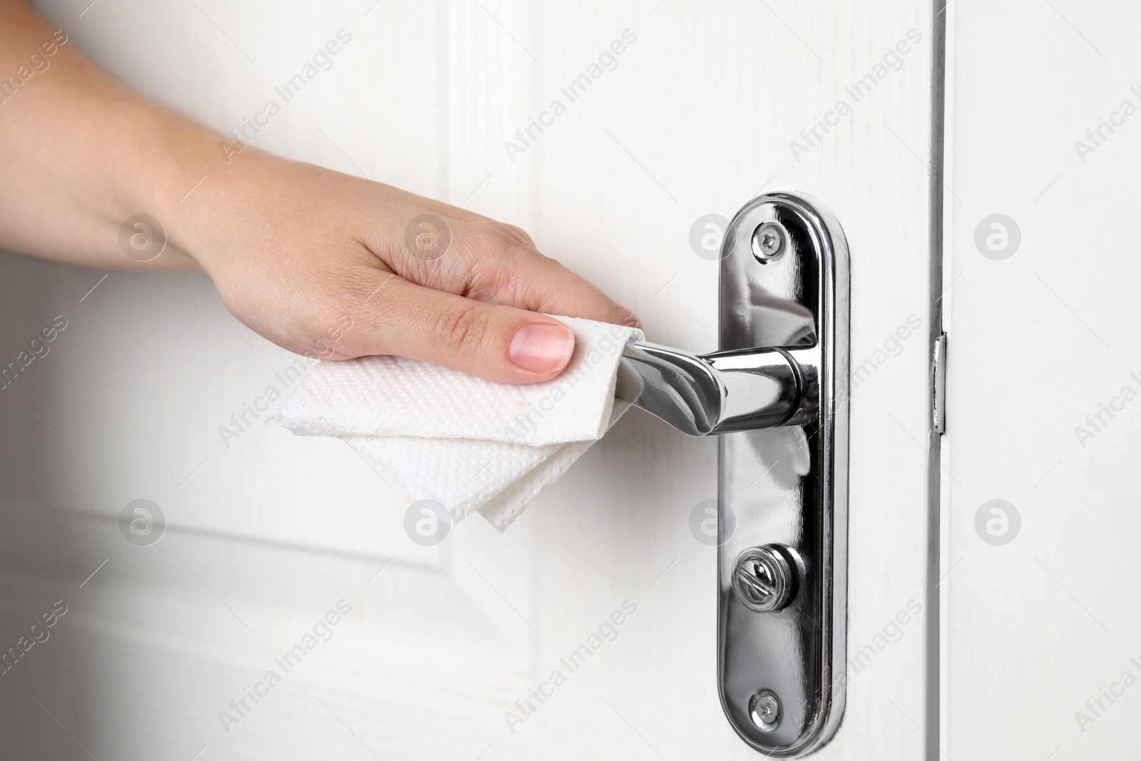 Photo of Woman using tissue paper to open door, closeup