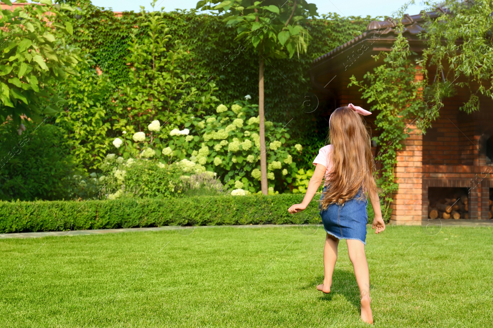 Photo of Cute little girl running in green park on summer day