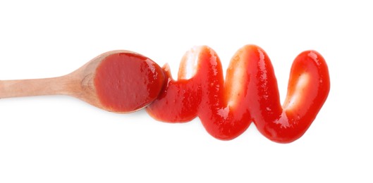 Spreading tasty ketchup with spoon on white background, top view. Tomato sauce