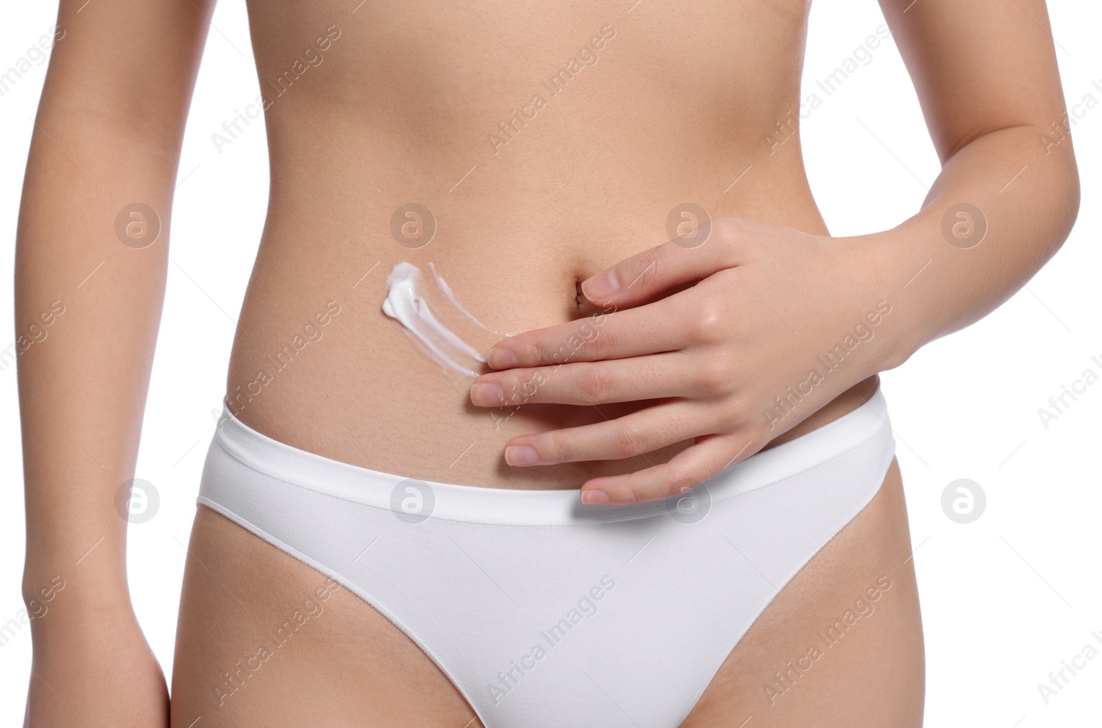 Photo of Young woman with body cream smear on belly against white background, closeup