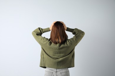 Girl wearing cardigan on white background, back view