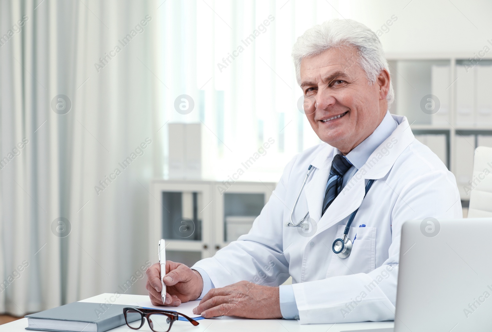 Photo of Portrait of senior doctor in white coat at workplace