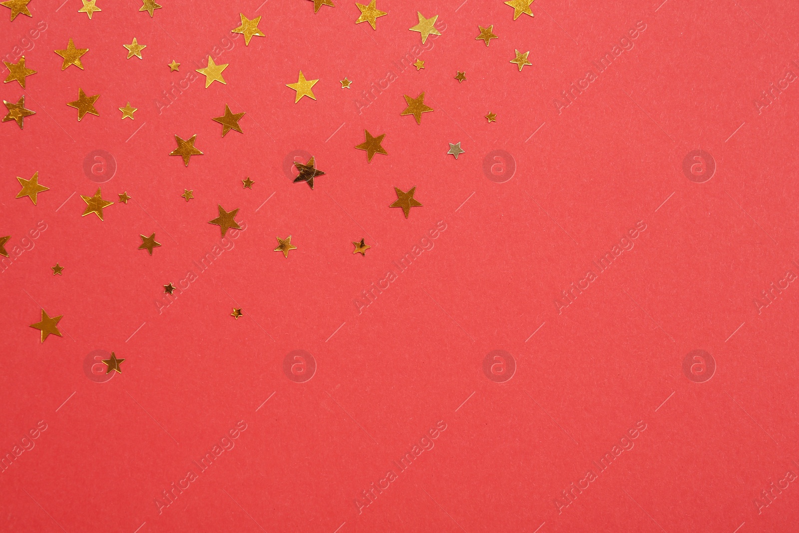 Photo of Star shaped confetti on red background, flat lay. Space for text