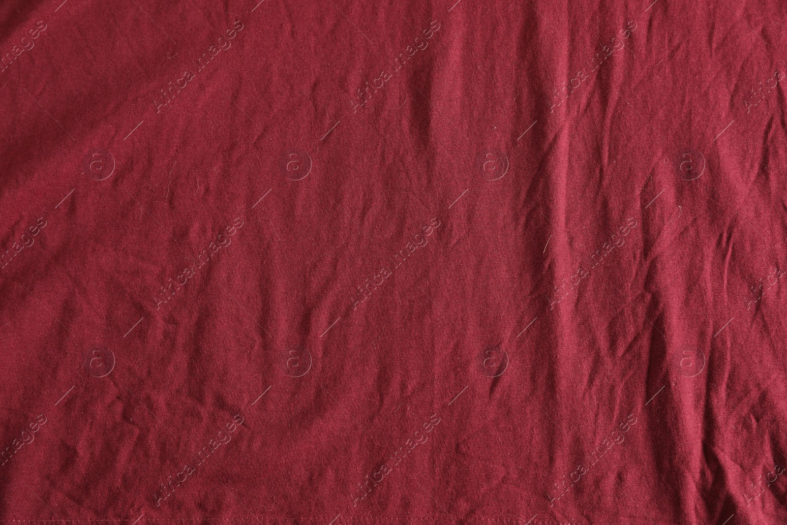 Photo of Crumpled dark red fabric as background, top view