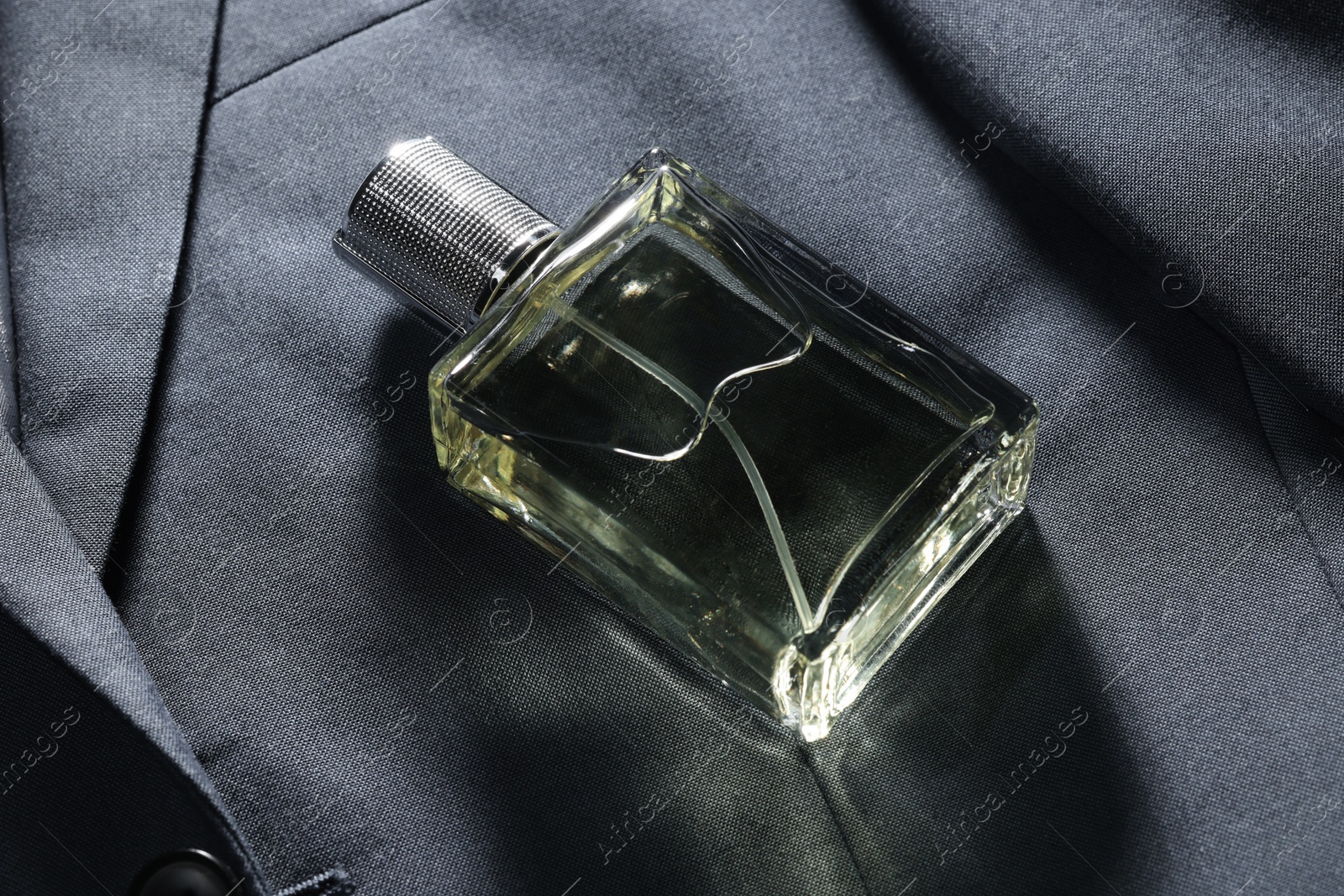 Photo of Luxury men's perfume in bottle on grey jacket