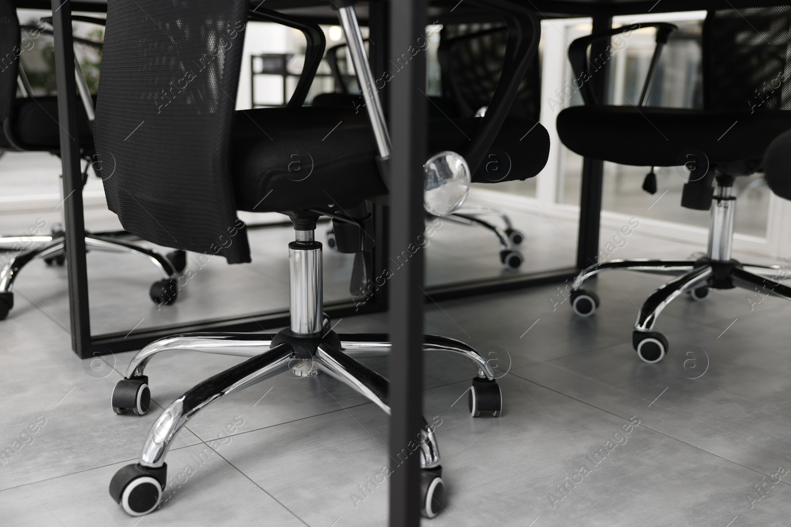 Photo of Comfortable office chairs and tables in meeting room, closeup