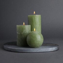 Photo of Set of burning candles on grey background