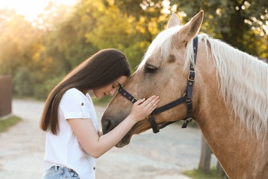 Beautiful woman with adorable horse outdoors. Lovely domesticated pet