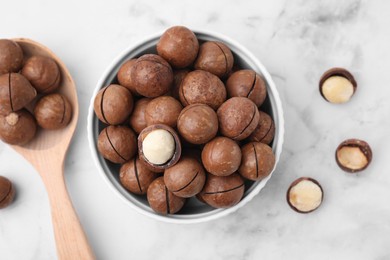 Photo of Tasty Macadamia nuts on white marble table, flat lay