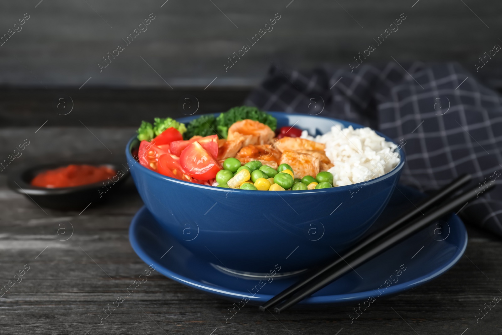 Photo of Bowl of boiled rice with vegetables and meat on table