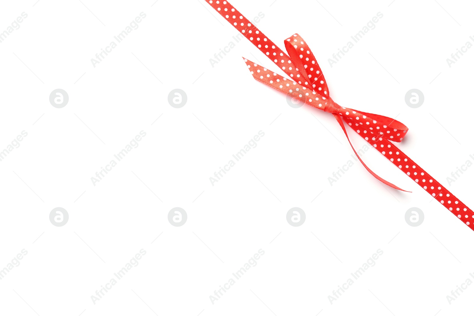 Photo of Red ribbon with bow on white background. Festive decoration