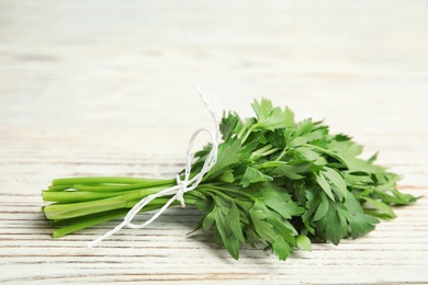 Photo of Bunch of fresh green parsley on wooden background. Space for text