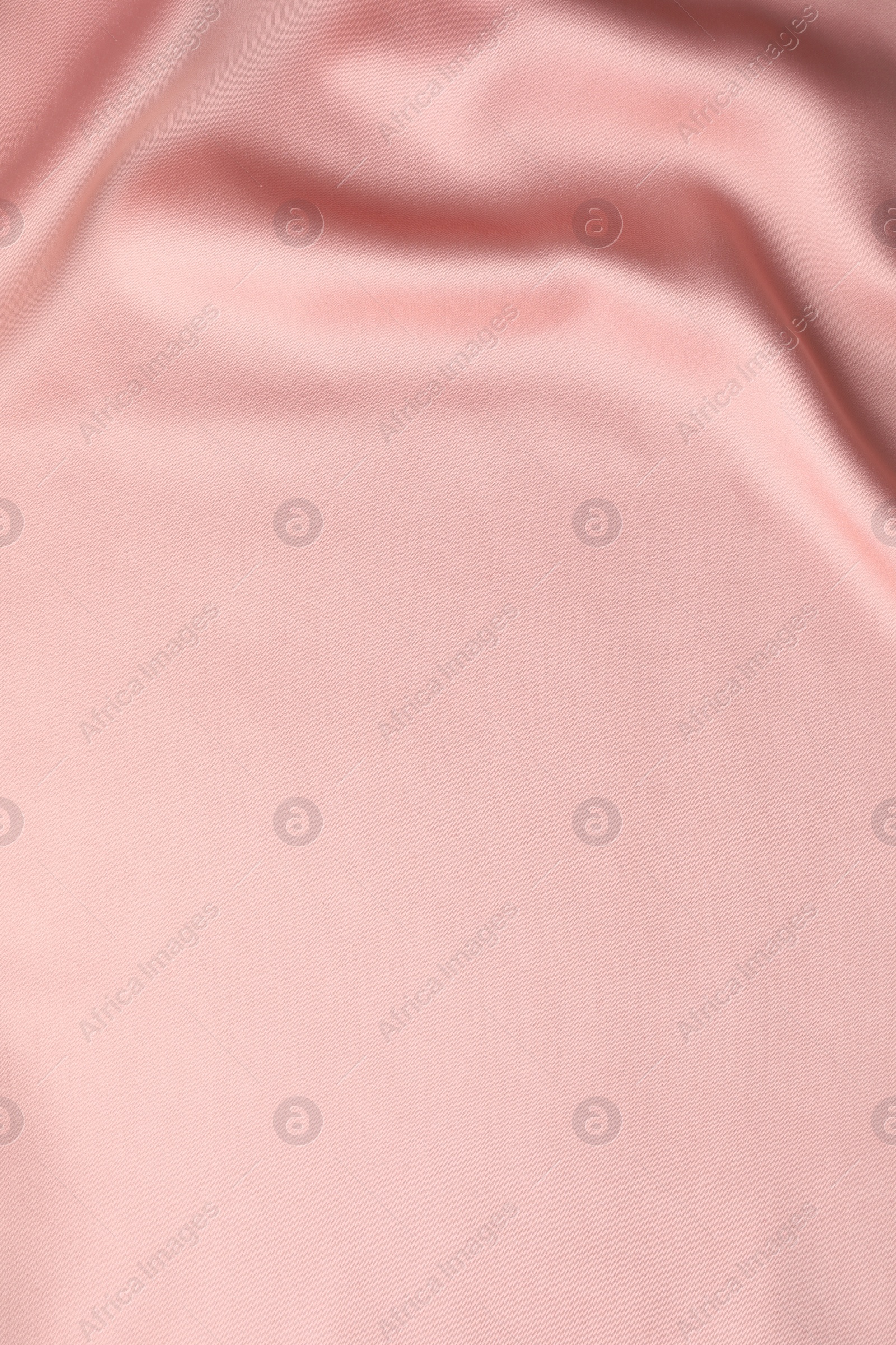 Photo of Crumpled pink silk fabric as background, top view. Space for text