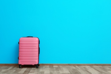 Photo of Packed suitcase near color wall with space for text