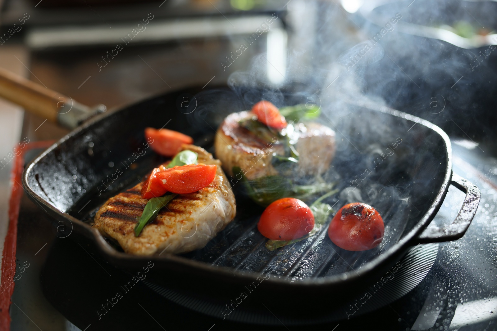 Photo of Grill pan with meat, spinach and tomatoes on stove, closeup