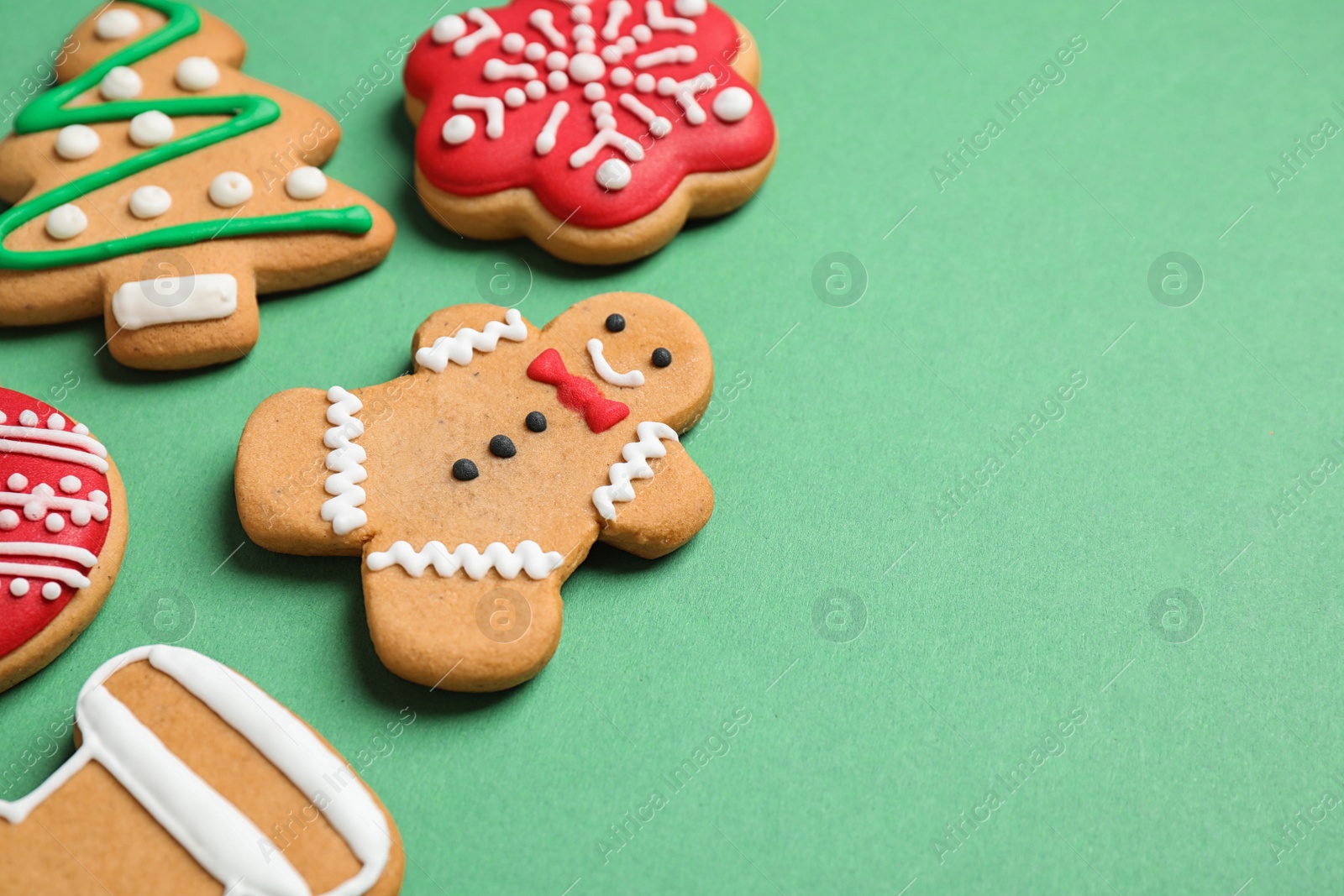 Photo of Tasty homemade Christmas cookies on green background, space for text