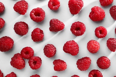 Tasty ripe raspberries on white background, flat lay