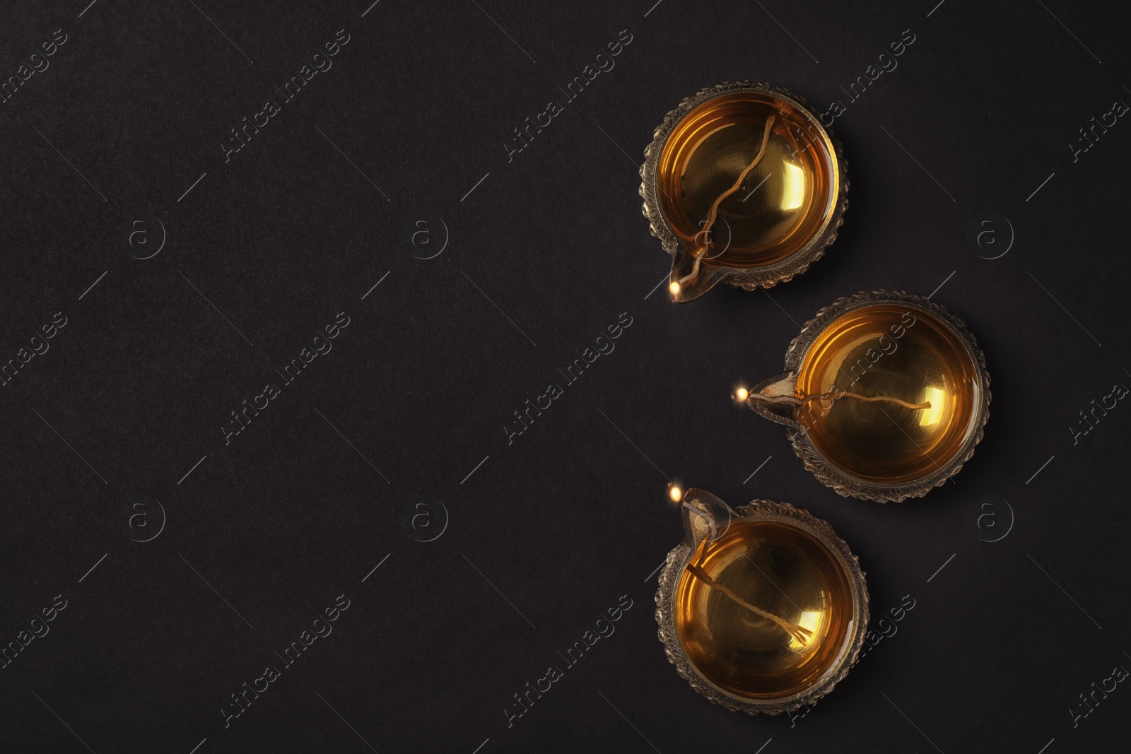 Photo of Diwali diyas or clay lamps on dark background, top view