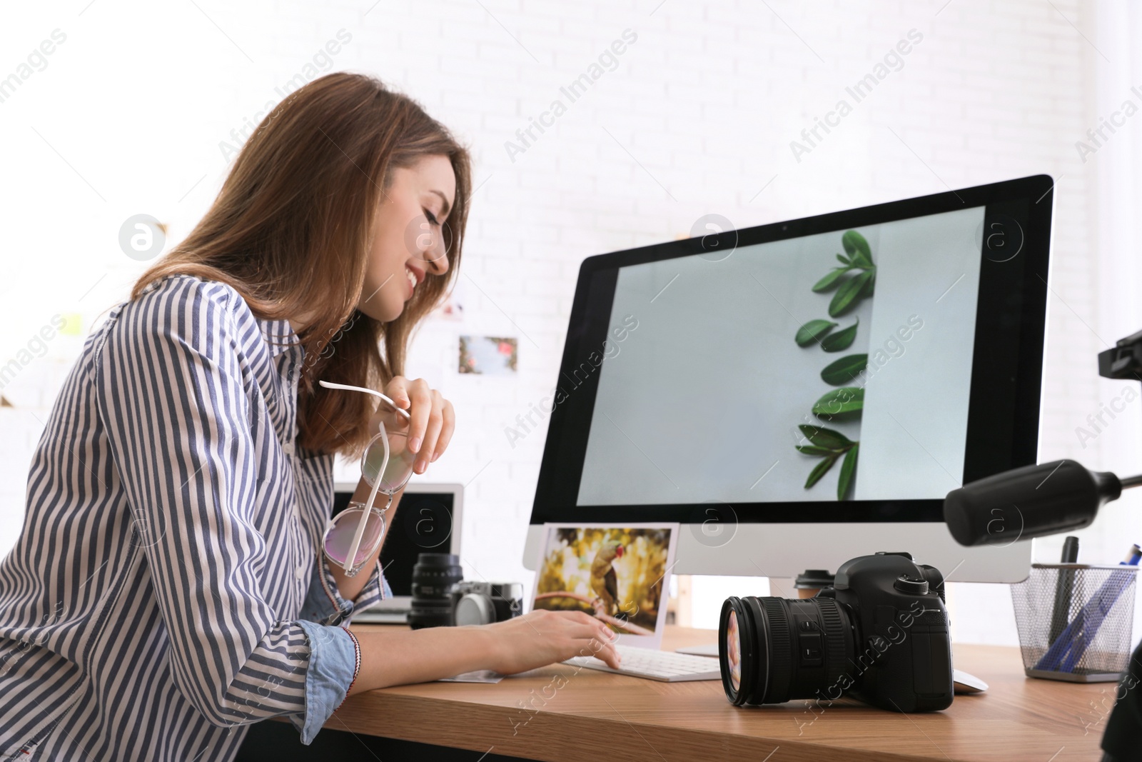 Photo of Professional photographer working at table in office