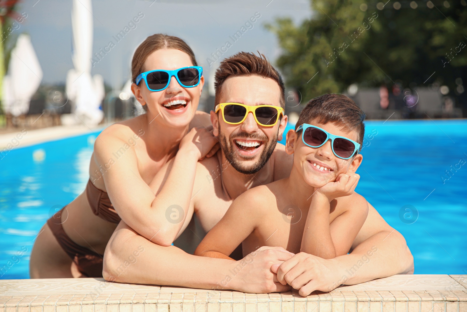 Photo of Happy family in swimming pool on sunny day