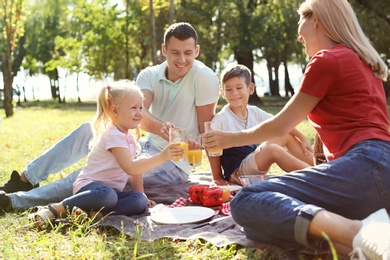 Happy family having picnic in park on sunny day